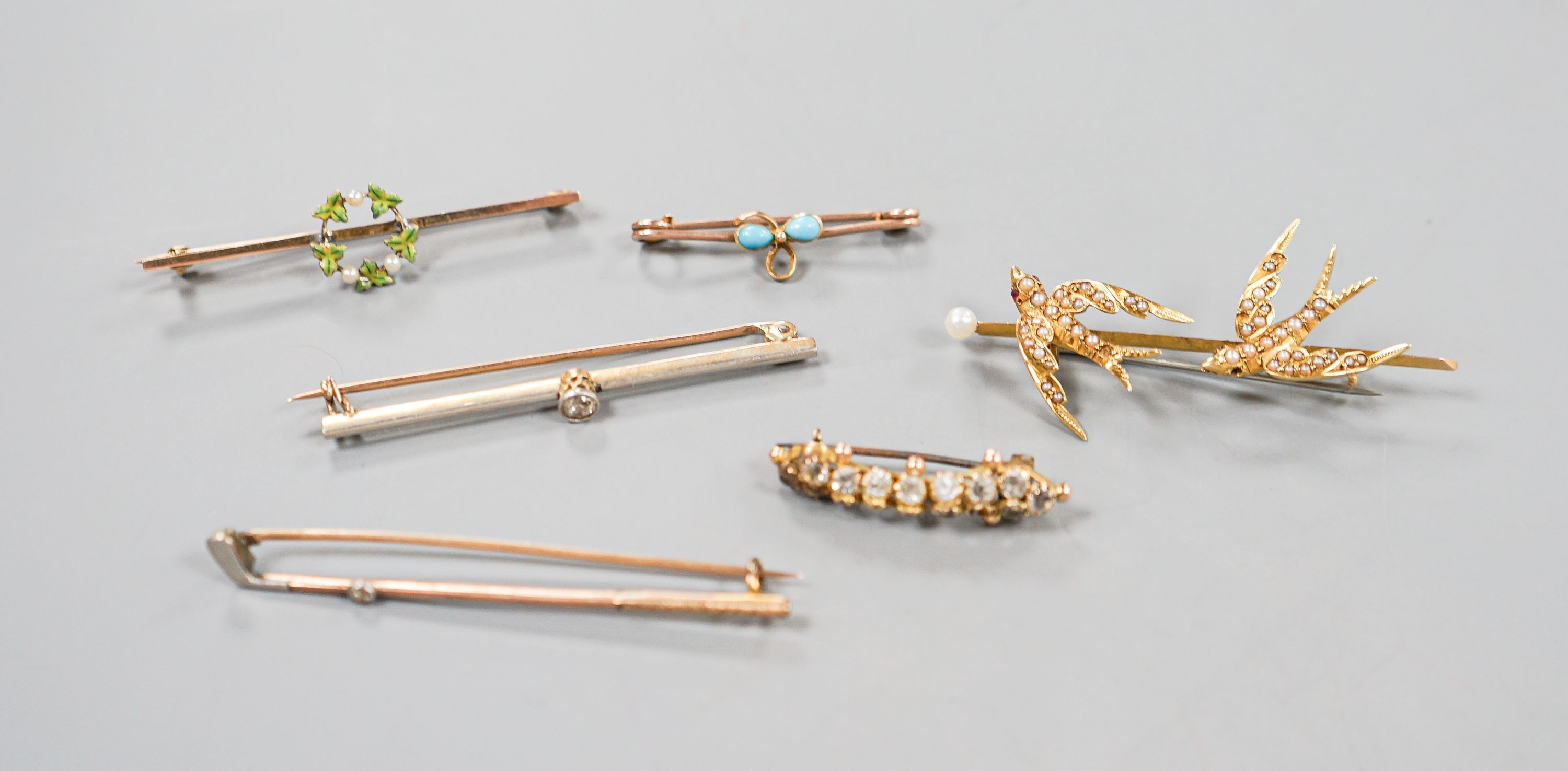 A collection of six assorted yellow metal bar brooches, including seed pearl set twin swallow, diamond set gold club and solitaire diamond set